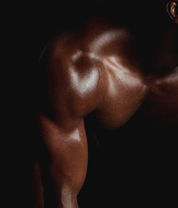 Man performing a controlled strength exercise in a dark gym with lime green light.